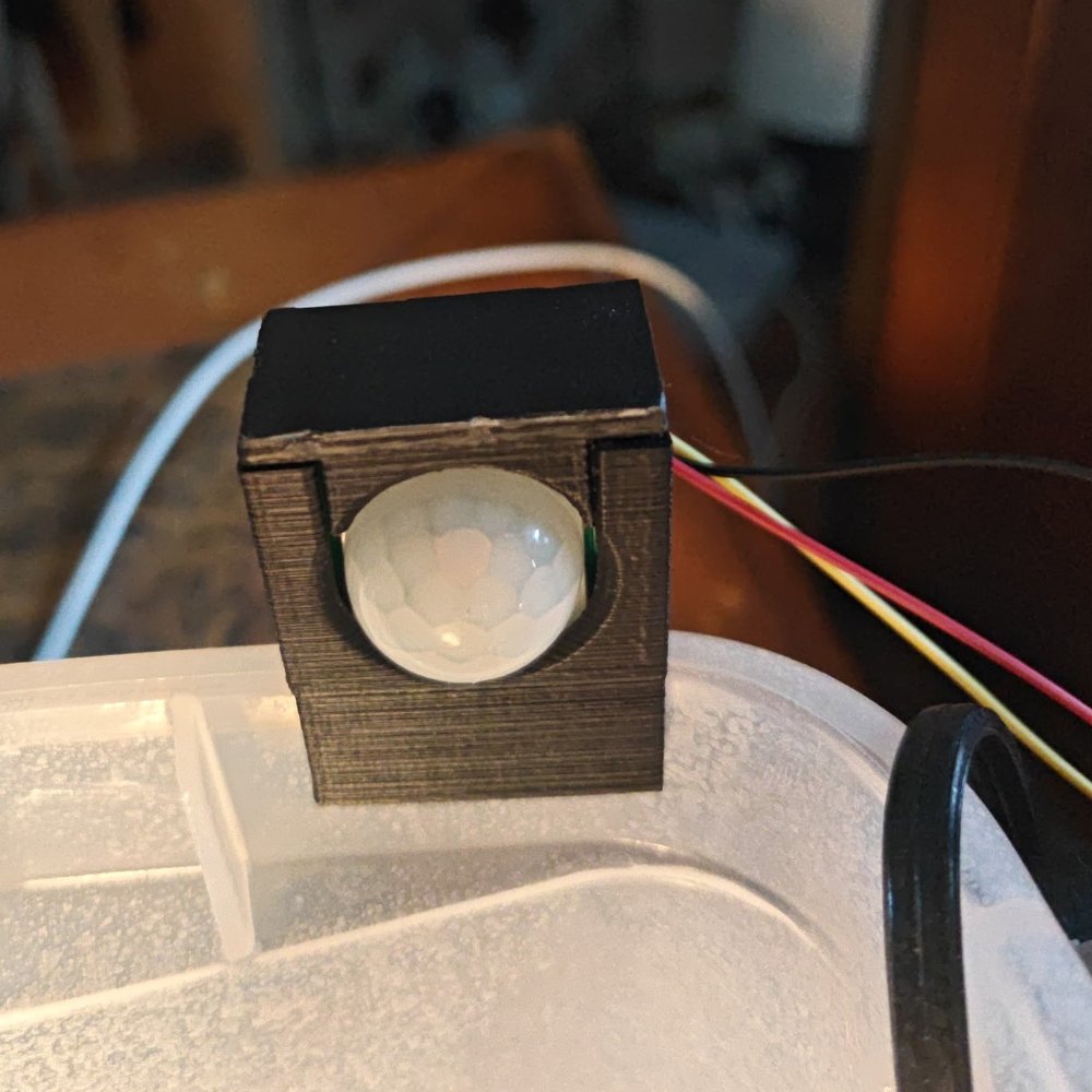 The printed PIR case clipped onto the turtle tote rim, lens dome facing out